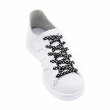 Photo of a single white trainer with the Sliwils Jazz Polka Black shoelace in it. 