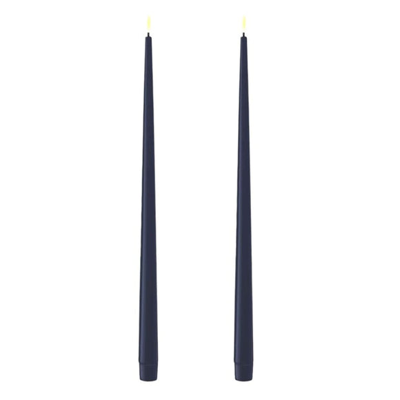Photo of 2 Royal Blue (almost Navy) 38cm tapered dinner candles. Their led flames are lit and they have black wicks.