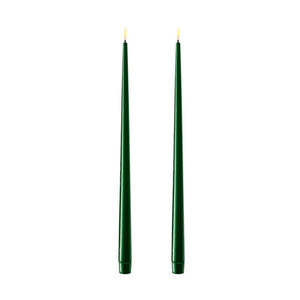 Photo of 2 dark green 38cm tapered dinner candles. Their led flames are lit and they have black wicks.