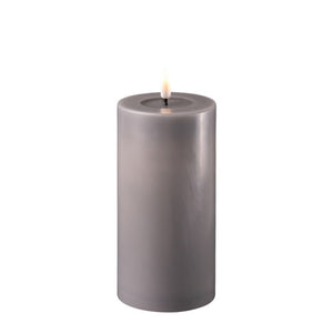 Image of a 15cm tall mocha coloured led candle. The wick is black and the electric flame is lit. Around the base of the wick is a transparent wax pool.