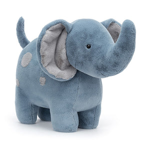 Photo of the Big Spottie Elephant from Jellycat. It has a large dusky blue body with little legs that allows it to stand up with no problem. Its inner ears and spots on its body are in a soft grey.