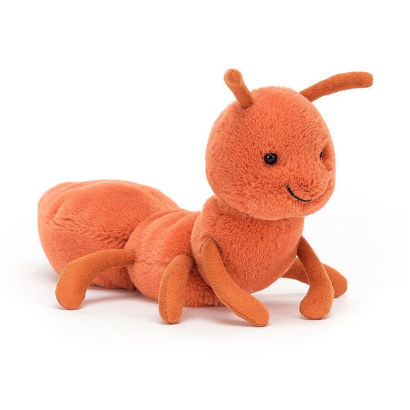 Photo of the Wriggidig Ant cuddly toy from Jellycat. It is completely orange apart from its black eyes and smile. It has 6 legs and 2 antenna. 