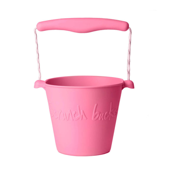 Photo of the Scrunch Bucket in Flamingo Pink. Its handle is made from a matching central piece of plastic and pink and white rope.