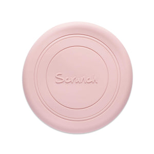 Photo of the Scrunch Flyer in old rose which is a pale pink. The frisbee is made from pale pink silicone and has some circular lines around it and the word Scrunch embossed in the centre.