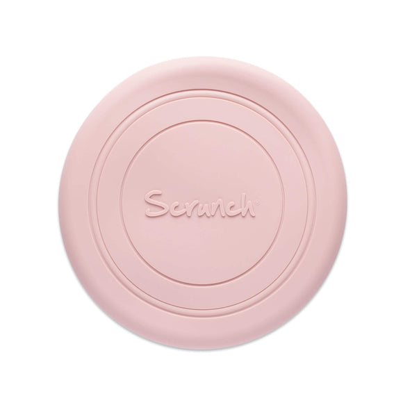 Photo of the Scrunch Flyer in old rose which is a pale pink. The frisbee is made from pale pink silicone and has some circular lines around it and the word Scrunch embossed in the centre.