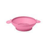 Photo of the Scrunch Panner in Flamingo Pink. This silicone panner can be used to sieve soil or sand or for water play. One of the handles is shaped as a snail and the other a fish.